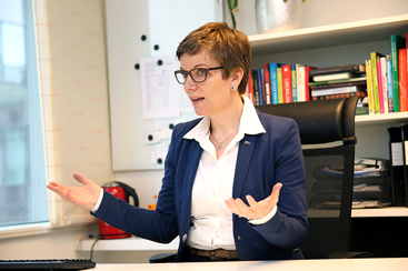 Marit Hermansen slår ut med hendene på kontoret.