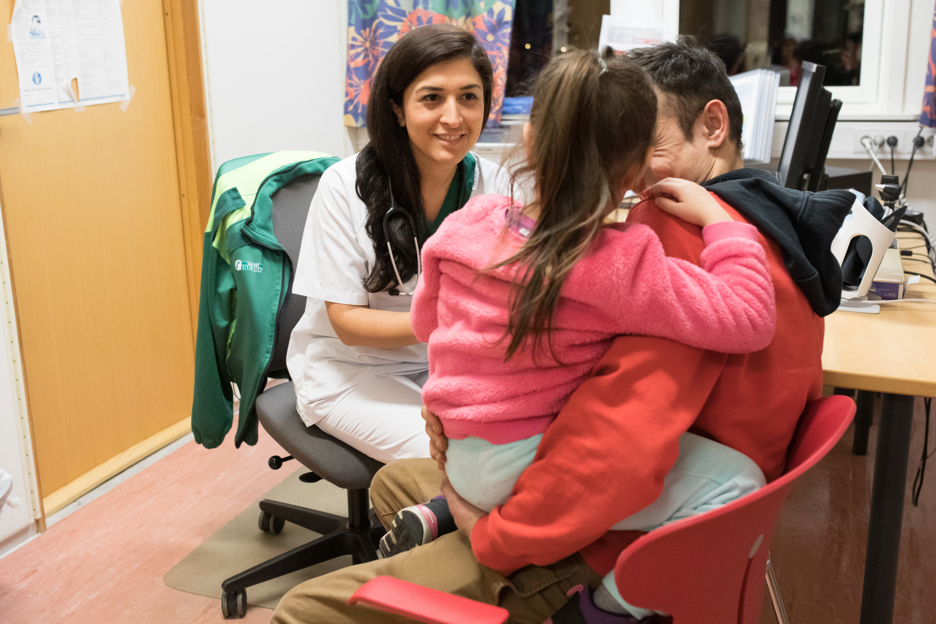 Female doctor with child patient and father