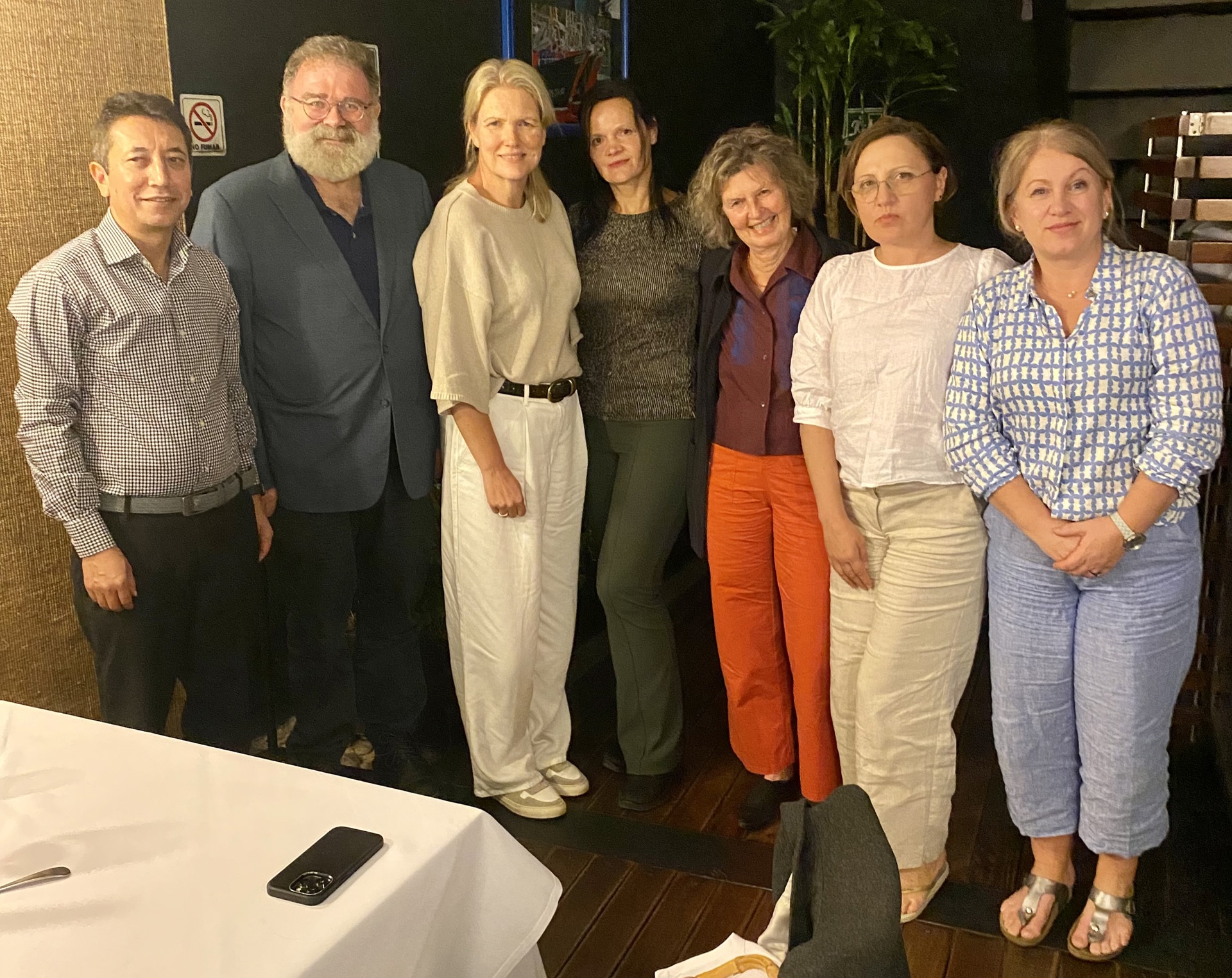 Bilde av syv psykiatere, to menn og fem kvinner, på restaurant.