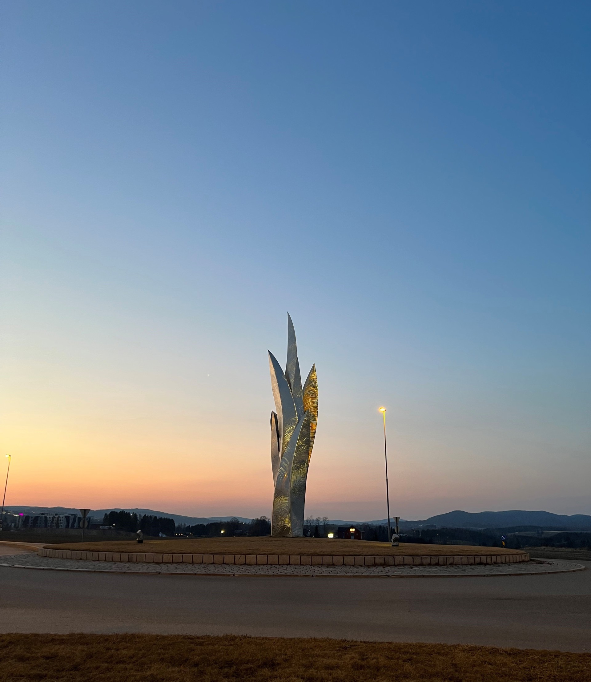 Monument i rundkjøring ved solnedgang.