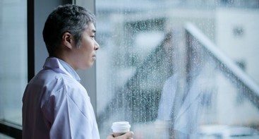 Mann som stirrer ut av vinduet på regnet. Foto: Istockphoto.com