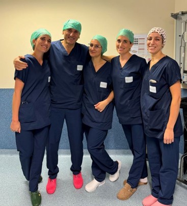 Bilde av fem kirurger som står sammen og smiler i operasjonsstuen. Foto: Mie Cappelen Skovholt