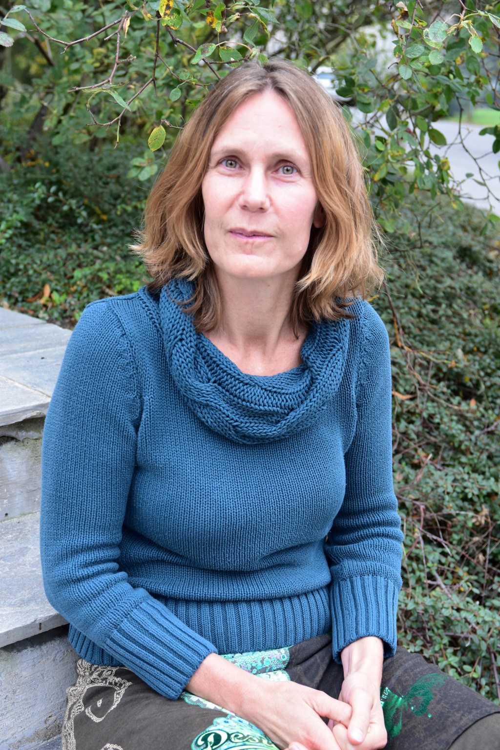 Woman sitting on outside stone stairs, Kjersti Nøkleby foto lisbeth nilsen