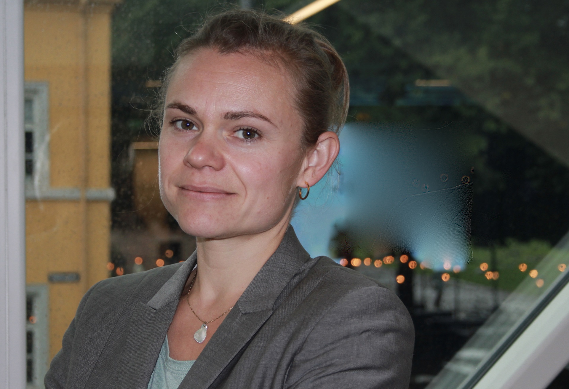 Bilde viser psykiater Anne Wold foran et vindu i Legenes hus