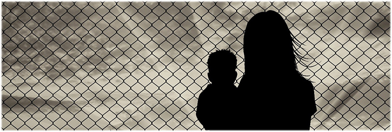 Bilde av to flyktninger ved et piggtrågjerde. Foto: Colourbox.com