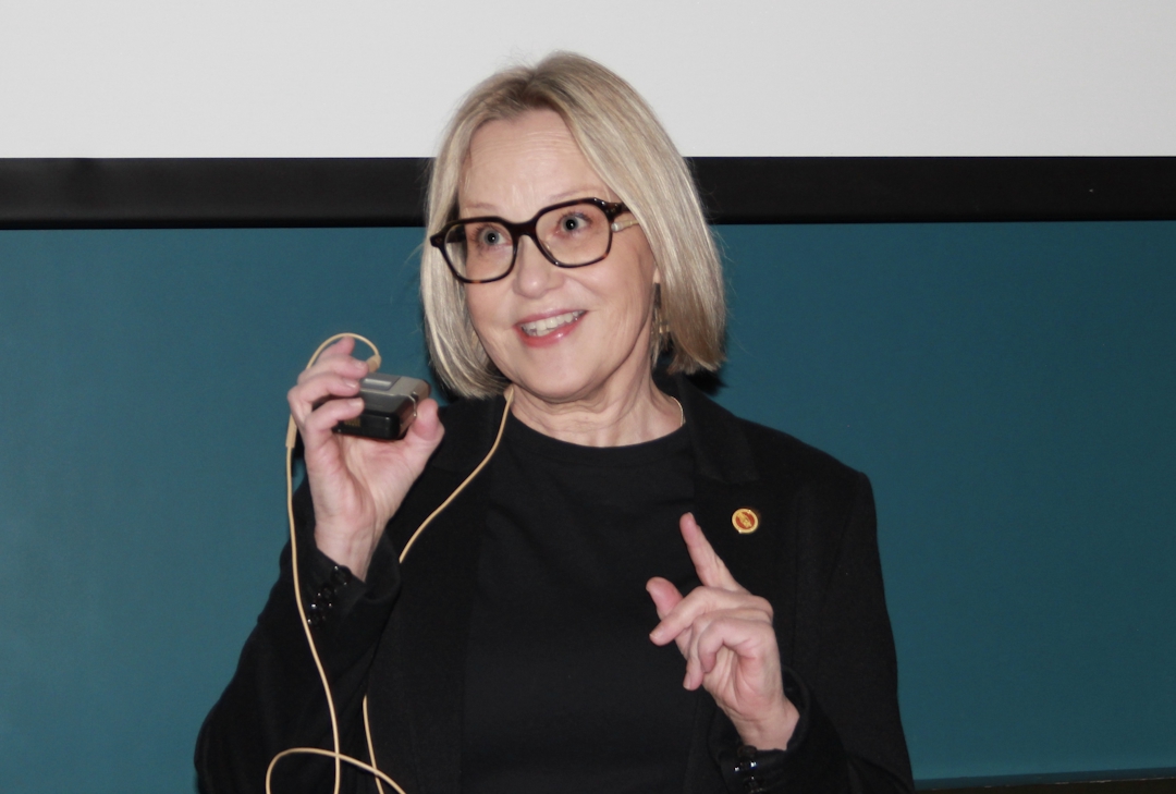 Kvinne med lyst hår som holder en trådløs mikrofon