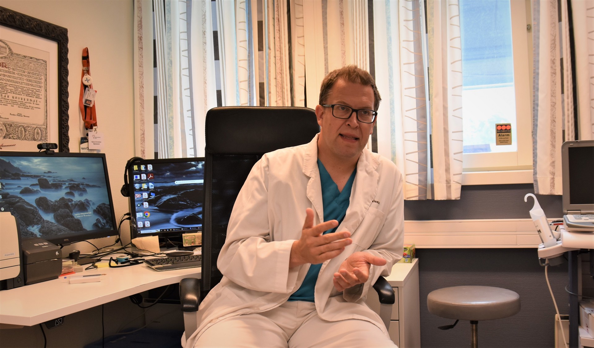 Lege i stol foran pulten på kontoret. Hans-Christian Myklestul, foto Lisbeth Nilsen