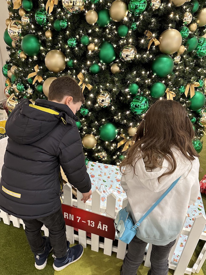 Foto til leder. 2 barn foran juletre