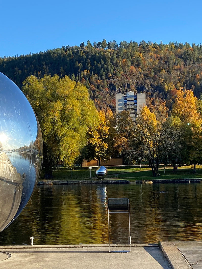 Bilde av elva i Drammen, to kuler og en blokk i bakgrunn. Foto: Tove Tveitan Borgen