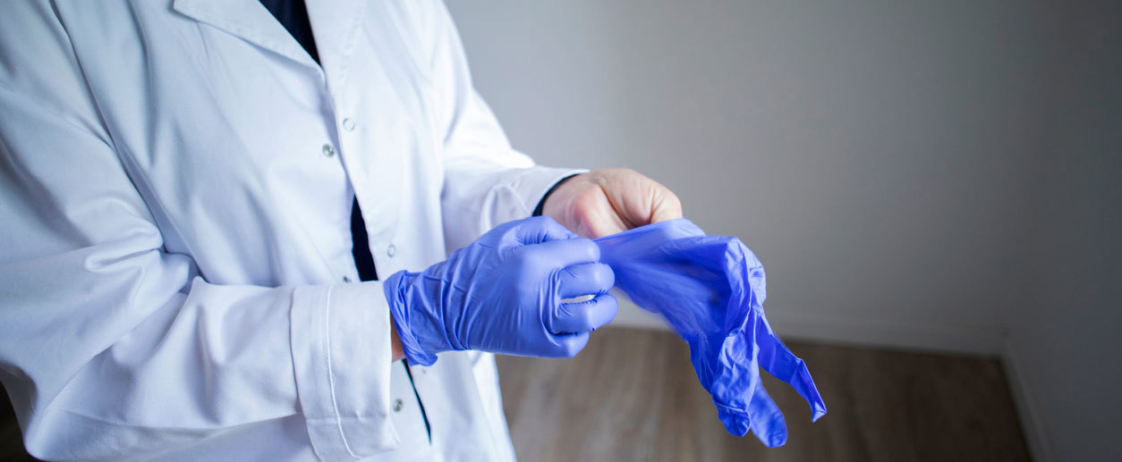 En lege som tar på legehansker. Foto: Istockphoto.com/DarioGaona