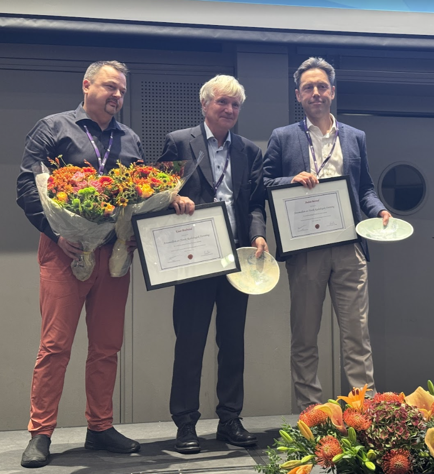 3 personer med diplomer og blomster