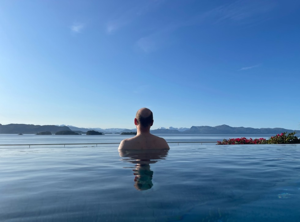 Mann i basseng som ser utover havet. Foto:privat