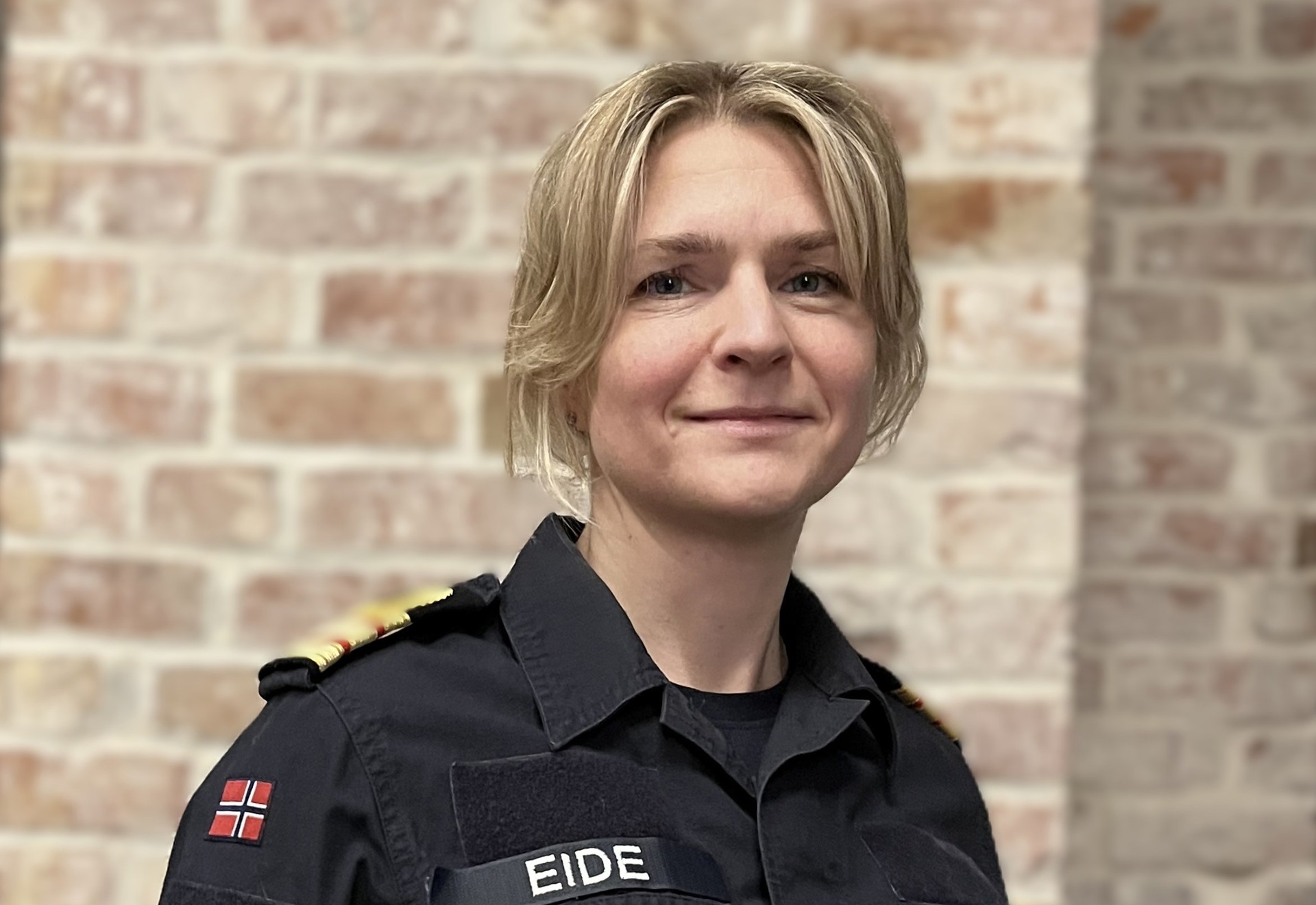 Smilende kvinne med lyst hår. I uniform fra Forsvaret.