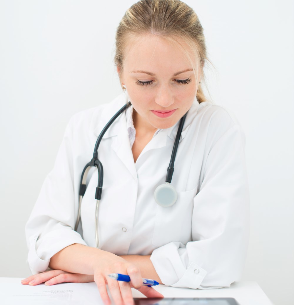 Kvinnelig lege som leser på en ipad. Foto: Colurbox.com