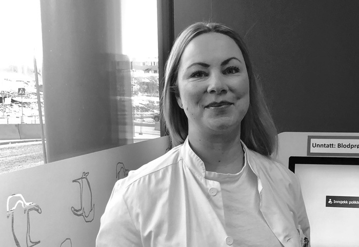 To eldre personer sitter på en benk og ser ut mot havet