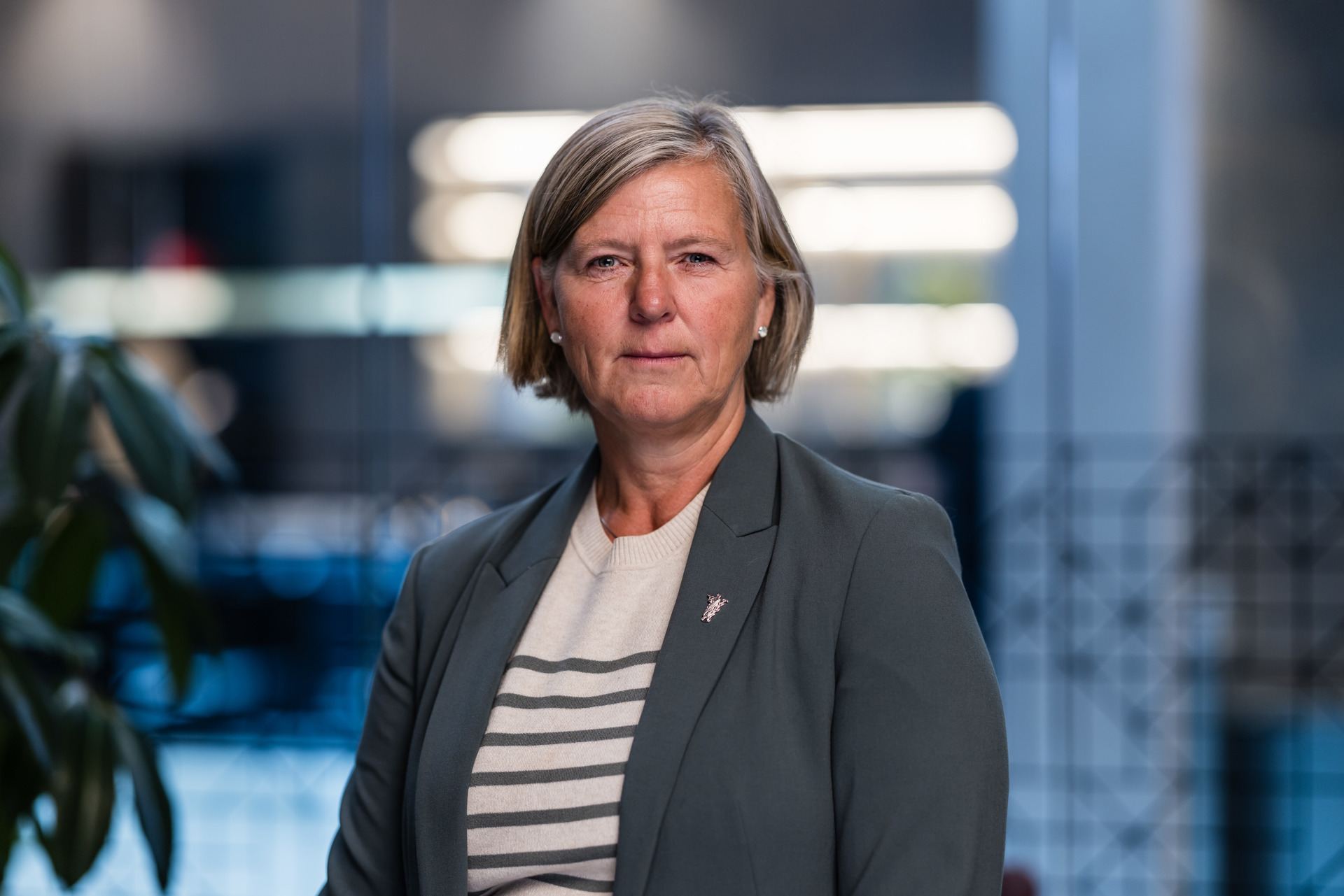 President i Legeforeningen, Anne-Karin Rime. Hun har lyst hår til haken, perleøredobber og ser avlorlig inn i kamera. Hun har på seg lysgrå dressjakke med stripete genser - grå og hvit - inni.