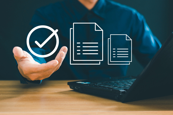 Foto illustrasjon av en mann i bakgrunnen med en PC foran seg. Foto: iStock/Pongsak Sapakdee