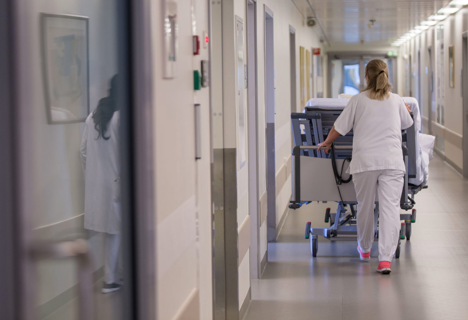 Sykepleier i en sykehus korridor som dyter en seng. Foto: Thomas B. Eckhoff