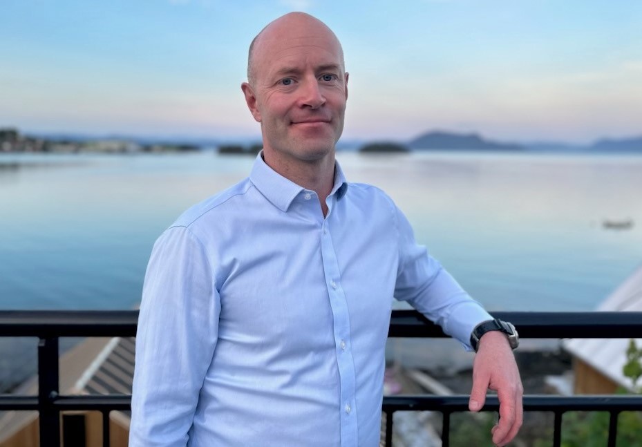 Mann i skjorte med hav i bakgrunnen. Kristian Rikstad Myklevoll, ph.d.-stipendiat og fastlege på Stord