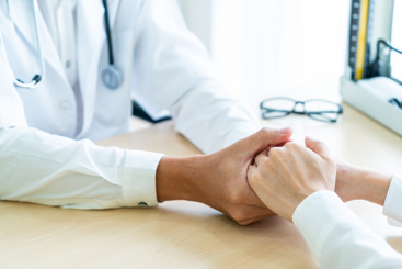 Bilde av en lege som holder hånden til en pasient. Foto: Topntp/Mostphotos