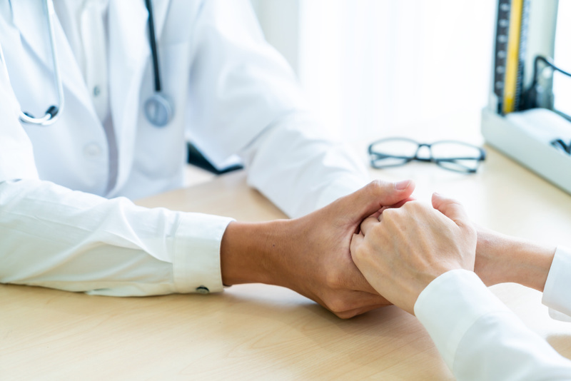 Bilde av en lege som holder hånden til en pasient. Foto: Topntp/Mostphotos