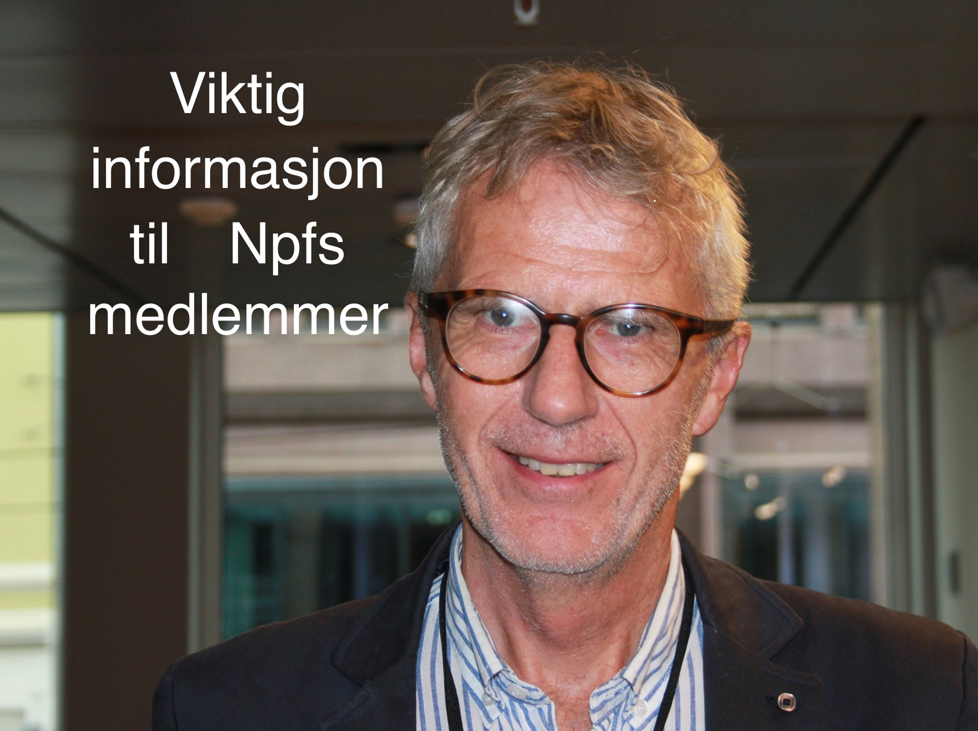 Smilende mann med briller og grått hår.